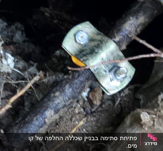 צינור מתכת עם תפסן וברגים באדמה